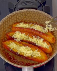 four hot dogs with cheese in a bowl