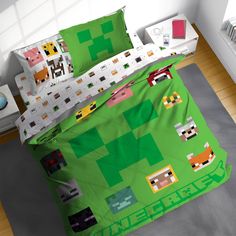 a bed covered in a green minecraft comforter and matching pillow cases with pillows