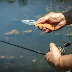 a man holding a fishing rod with a knife in it