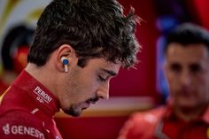 a close up of a person with ear buds in their ears looking at his cell phone