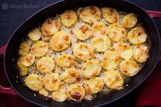 a skillet filled with potatoes on top of a red cloth