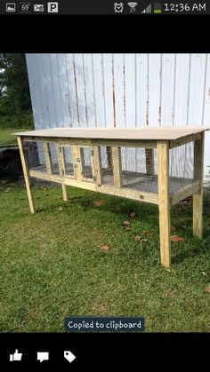 a wooden table sitting on top of a grass covered field