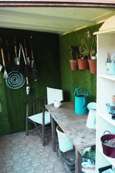 a kitchen with green walls and shelves filled with utensils