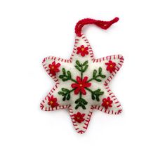 an ornament shaped like a star with red and green flowers on the side