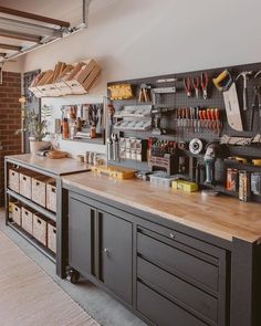 a workbench with lots of tools hanging on the wall and shelves above it