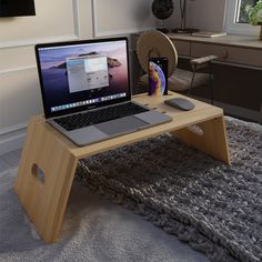 an open laptop computer sitting on top of a wooden table next to a mouse pad