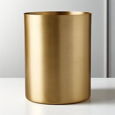 a gold colored vase sitting on top of a white table