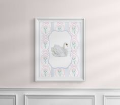 a white swan is hanging on the wall next to a fireplace with pink and blue trim