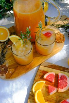 pitcher of orange juice with slices of watermelon and grapefruit on cutting board