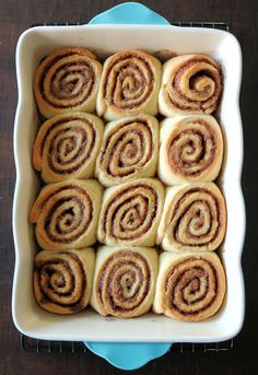 a baking dish filled with cinnamon rolls on top of a blue plate