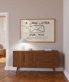 a poster on the wall above a wooden cabinet in a room with hardwood flooring