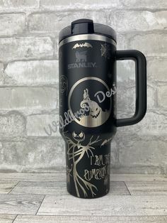 thermos travel mug is decorated with an image of a pumpkin and bats on it