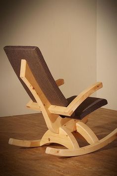 a wooden rocking chair sitting on top of a hard wood floor