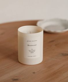 a white candle sitting on top of a wooden table