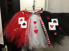 three tutu skirts with playing cards on them hanging from a hook in a closet