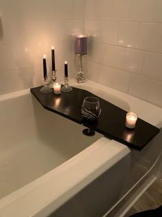 candles are placed on the edge of a bathtub