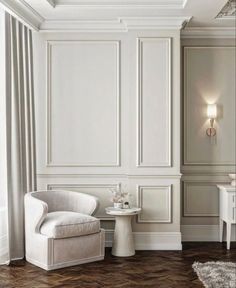 a white chair sitting next to a table on top of a hard wood floor in a room