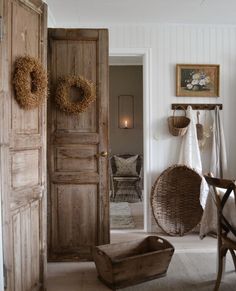 an open door leading to a bedroom with two chairs and a basket on the floor