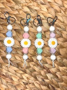 four key chains with flowers and beads on them