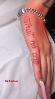 a woman's hand with the word god on it and an inscription written in red ink