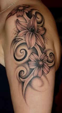 a woman's shoulder with flowers and swirls on it