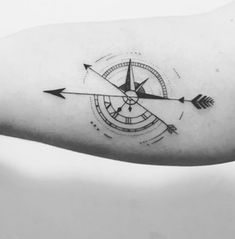 an arrow and compass tattoo on the arm