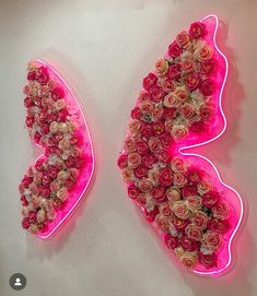 two pink neon signs with roses in the shape of an angel and a heart on them