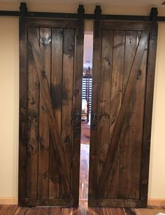 two large wooden doors are open on the floor in front of a door that has been made out of wood