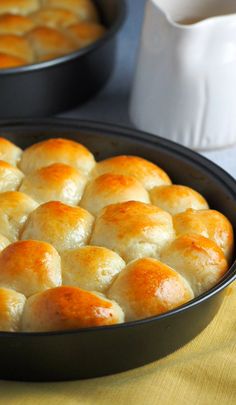 a pan filled with rolls sitting on top of a wooden table