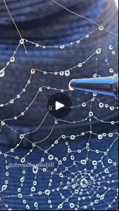 water droplets are hanging from a wire with a blue sky in the background and a video screen showing how to use it