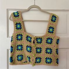 a crocheted top hanging on a door