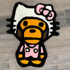 a hello kitty rug on the floor with a dog in it's head and bow tie