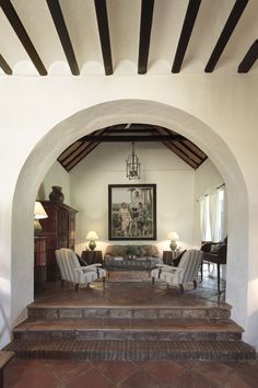 an archway leading to a living room with two chairs