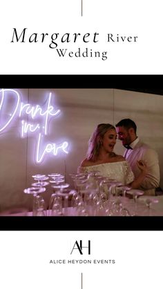 a couple standing next to each other in front of a neon sign