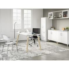 a room with a desk, chair and bookcases in white color is shown