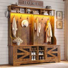 a wooden bench with coat racks and shoes on it in front of a white wall