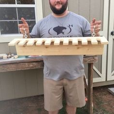 a man standing in front of a house holding a musical instrument and giving the thumbs up sign