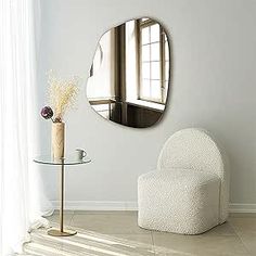 a white chair sitting in front of a round mirror on the side of a wall