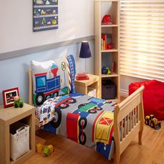 a child's bedroom with blue walls and wooden flooring, including a toy train bed