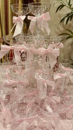 a table topped with lots of wine glasses covered in pink bows