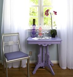 a purple table and chair in front of a window