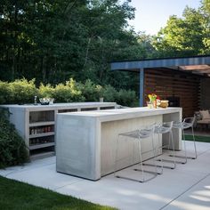 an outdoor bar with stools in front of it