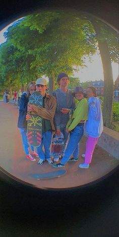 a group of people standing next to each other holding skateboards