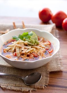 a white bowl filled with food on top of a wooden table