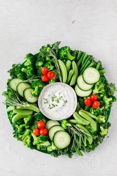 a platter filled with cucumbers, broccoli and other veggies