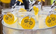 mason jars filled with yellow and white party favors for a bicycle themed birthday or baby shower