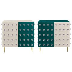 a pair of green and white side tables with metal studs on the sides,