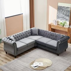 a living room with a gray sectional couch and rug on the floor in front of a large window