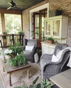 a living room filled with lots of furniture and plants on top of a wooden floor