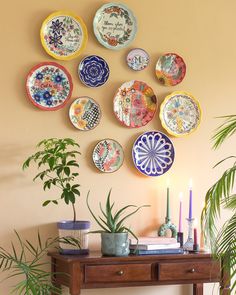 a table topped with lots of plates on top of it next to a potted plant